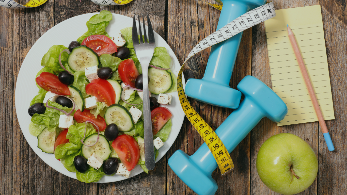 Prato de legumes, ao lado de halteres e fita métrica, para falar sobre dieta após a cirurgia bariátrica