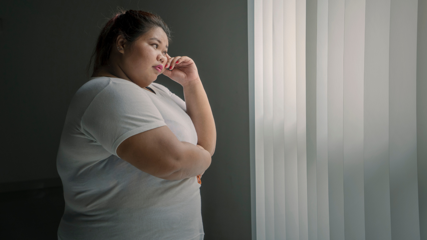 Mulher obesa pensando em cirurgias bariátricas menos invasivas