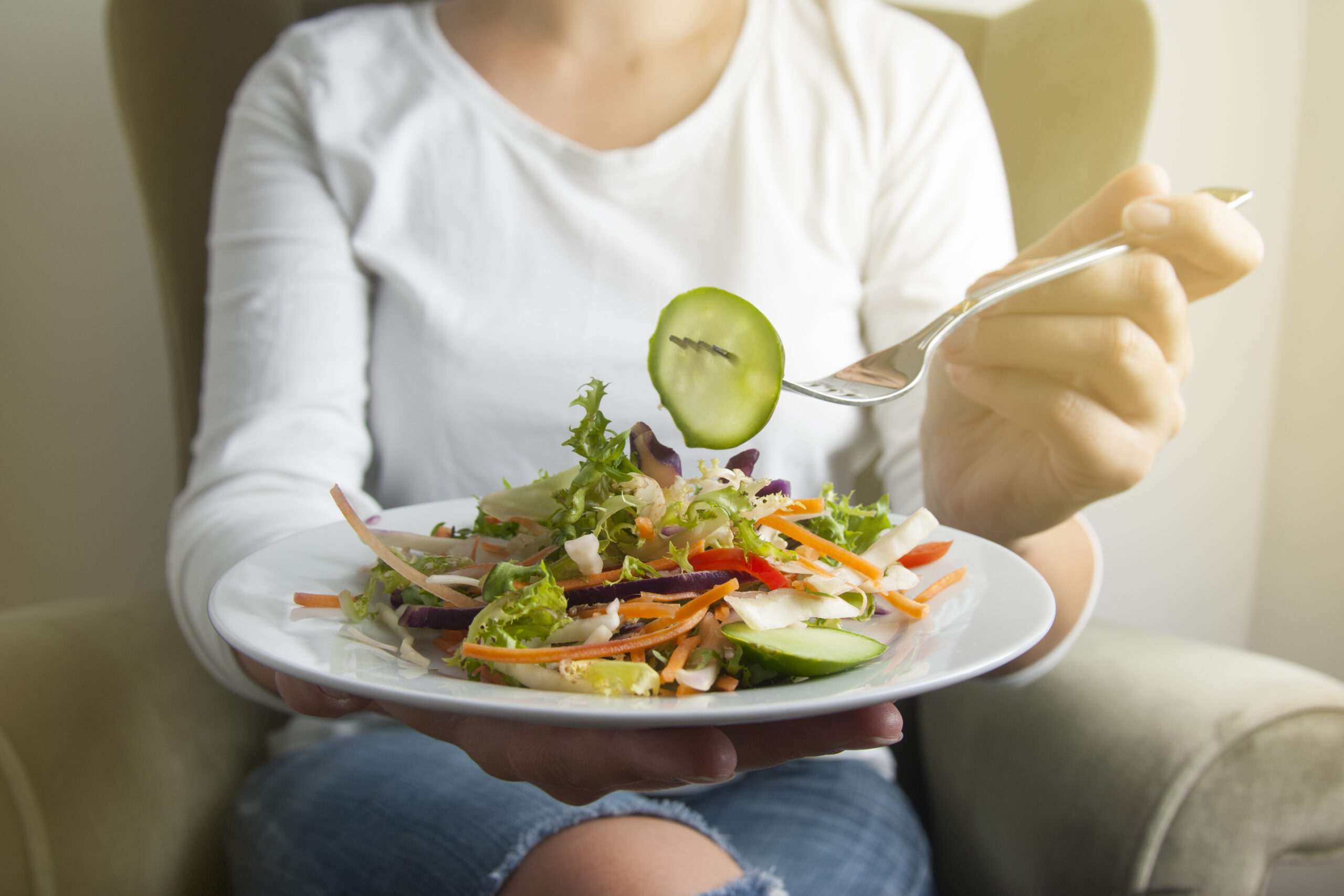 Mulher comendo salada e pensando por que não emagrece