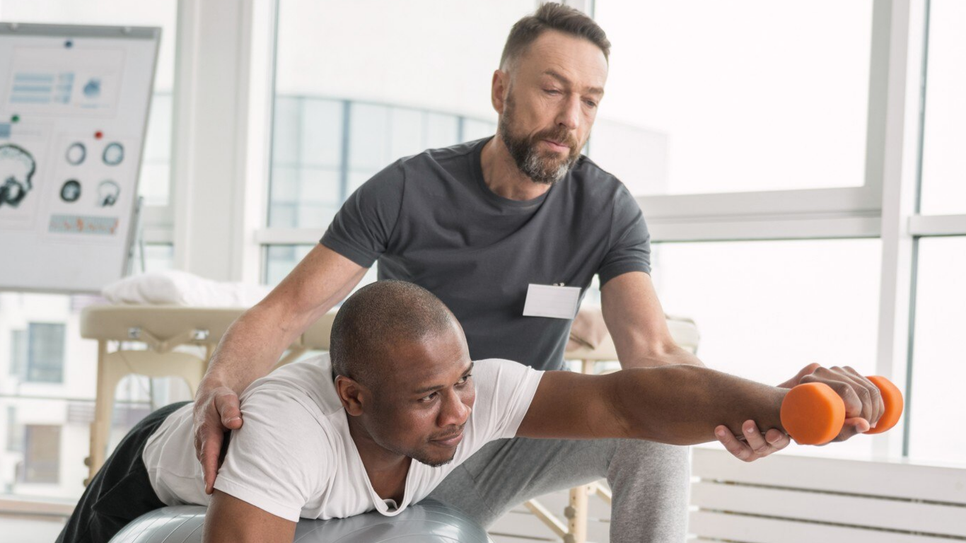 Homem com hérnia fazendo aexercícios físicos com ajuda profissional