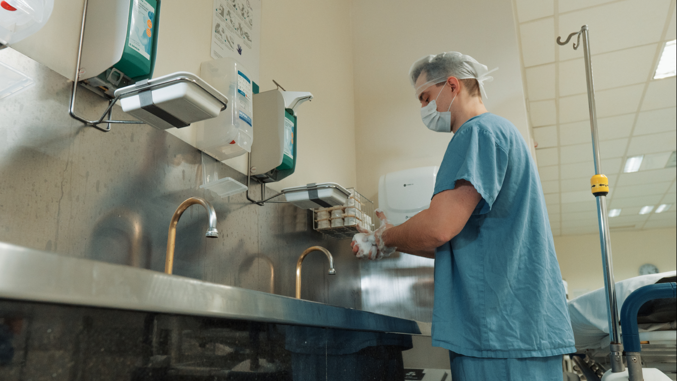 Médico lavando as mãos, no preparo pré-operatório da cirurgia